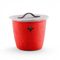 Petit panier Baabuk en laine feutrée rouge, avec un grey , une poignée en cuir et un motif en forme de croix suisse découpée.