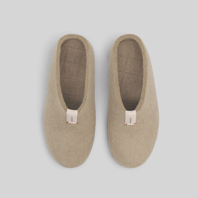 A pair of beige wool slip-on slippers shown from a top-down view on a light gray background.