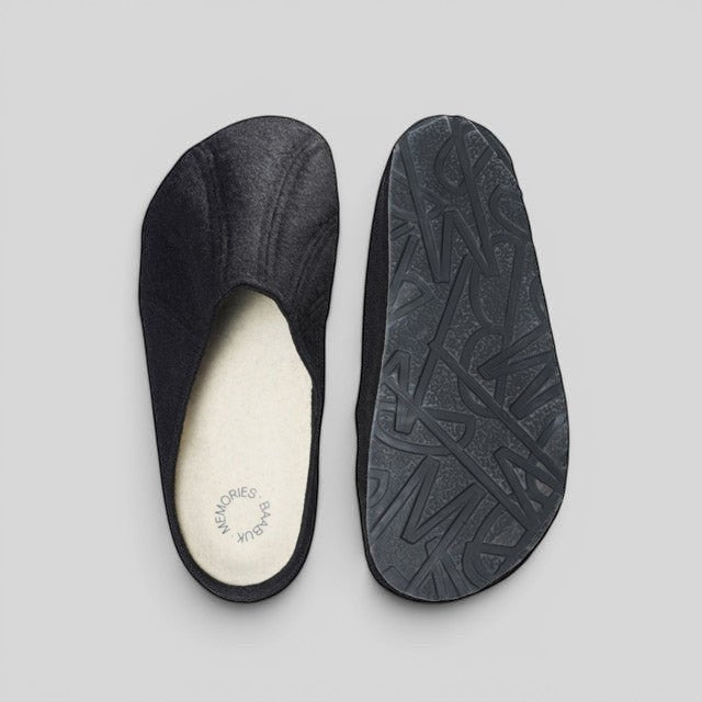 Baabuk Alpina black wool slip-on sandals with cork insole and patterned rubber outsole on a grey background.
