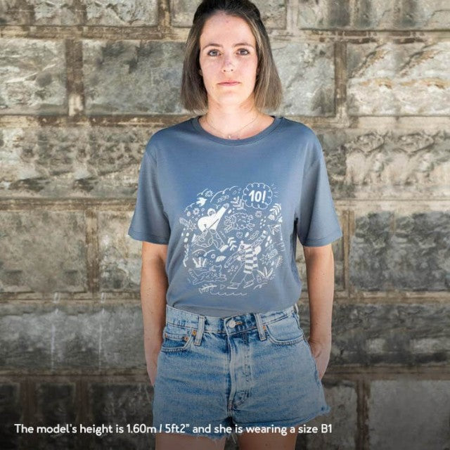 Model wearing a dark grey Baabuk 10-year anniversary merino wool t-shirt with a white graphic illustration.