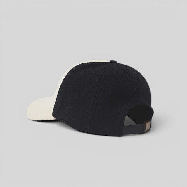 Baabuk Blacknose baseball cap in black and off-white wool with an adjustable leather strap, rear view.