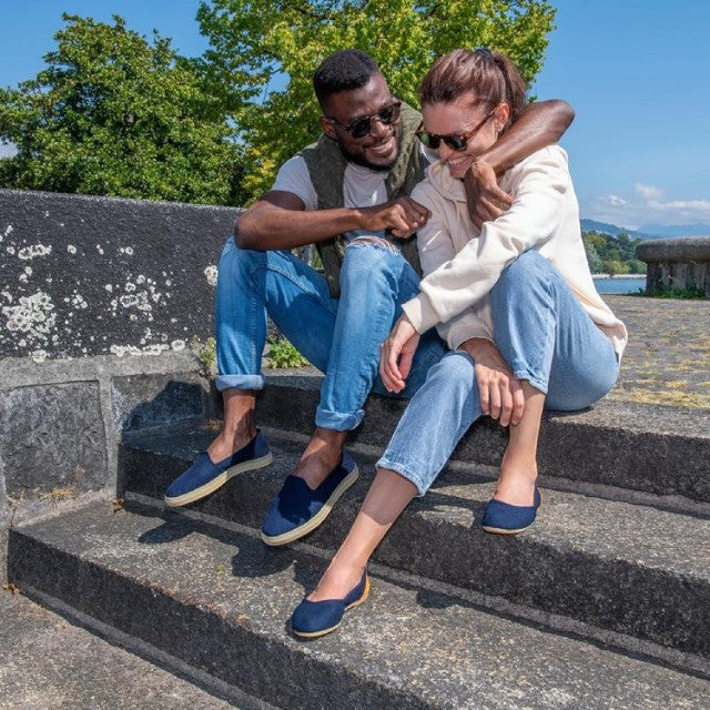 Baabuk blue wool ballerina flats worn by a woman sitting on stone steps with a man outdoors.