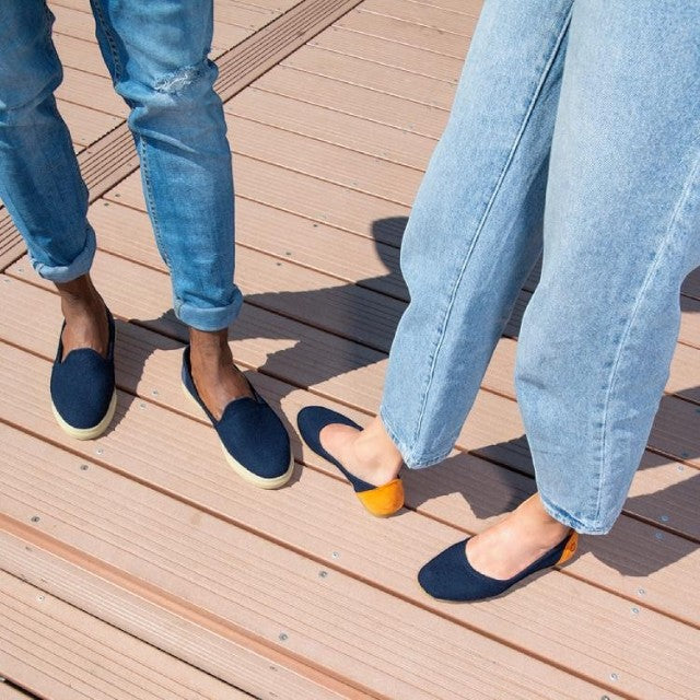 Baabuk blue wool ballerina flats with nubuck heel detail worn by a person on a wooden deck.