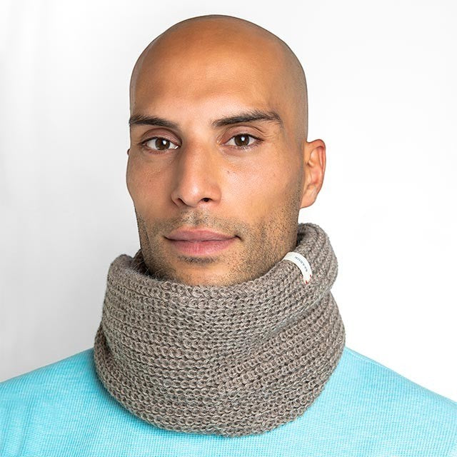 Man wearing a brown Baabuk infinity scarf made from soft baby alpaca wool, featuring a circular knit design.