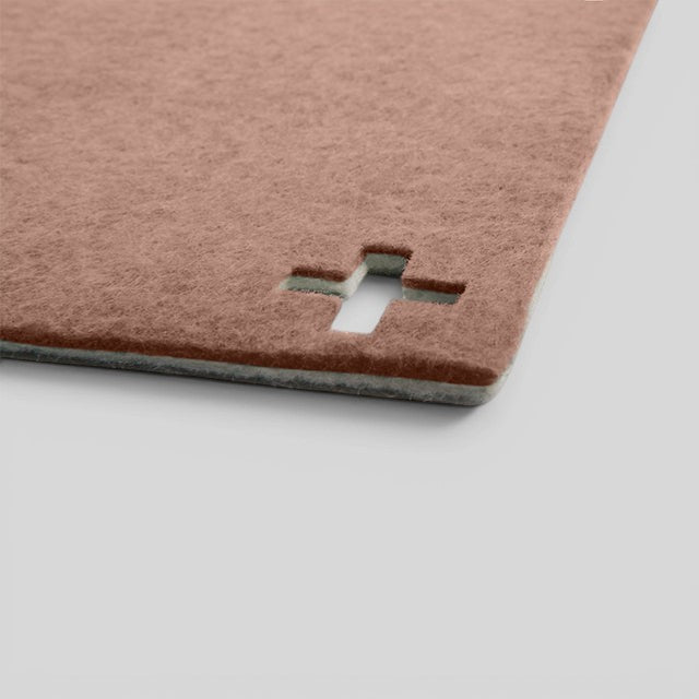 Baabuk brown felted wool table mat with a Swiss cross cutout detail, handmade from natural New Zealand wool.