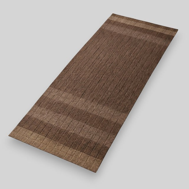 Baabuk brown felted wool yoga mat with textured surface and minimalist striped design for natural cushioning.
