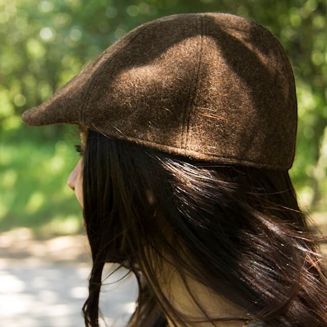 Baabuk brown wool beret inspired by traditional Portuguese shepherd hats, worn by a woman outdoors.