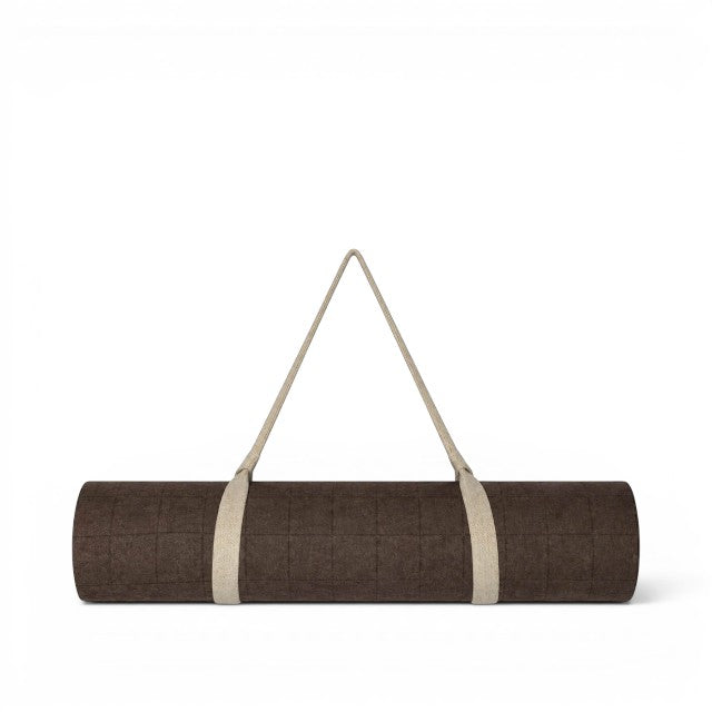 Baabuk brown felted wool yoga mat rolled up with a beige cotton carrying strap against a white background.
