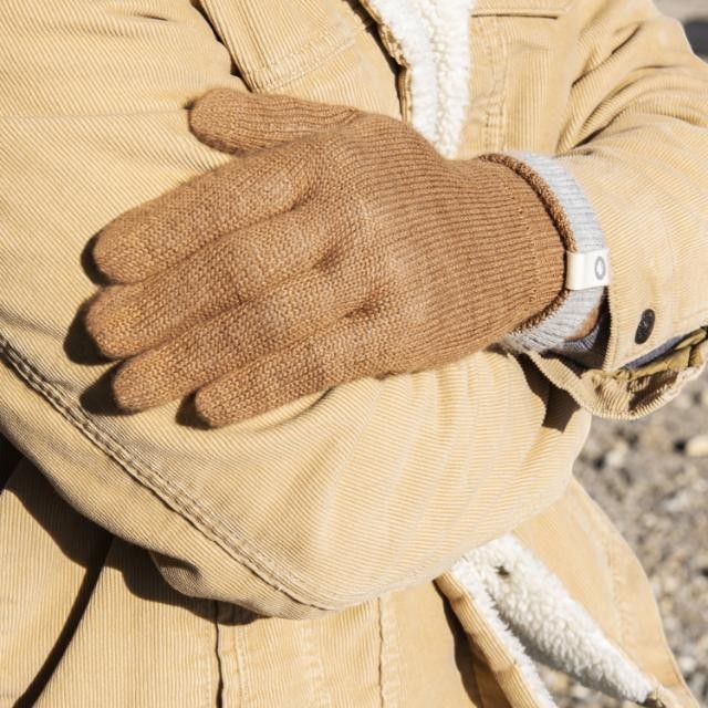 Baabuk camel-colored baby alpaca wool gloves worn with a tan corduroy jacket for winter warmth.