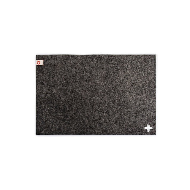 Baabuk dark grey felted wool table mat with a small white Swiss cross detail and brand label.