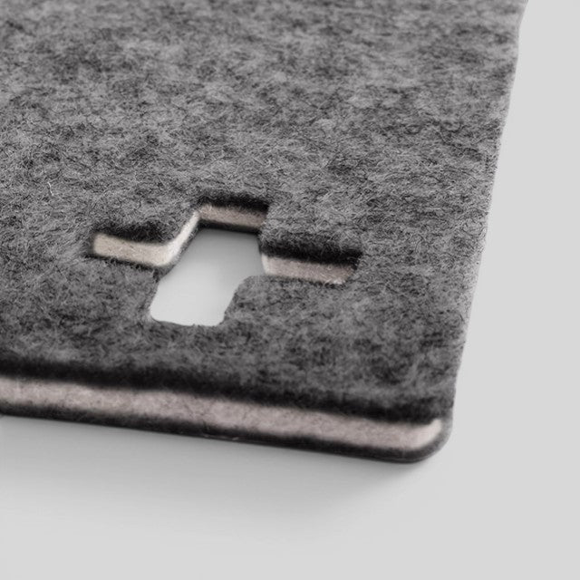 Baabuk dark grey felted wool table mat with a Swiss cross cutout design, handmade from natural New Zealand wool.