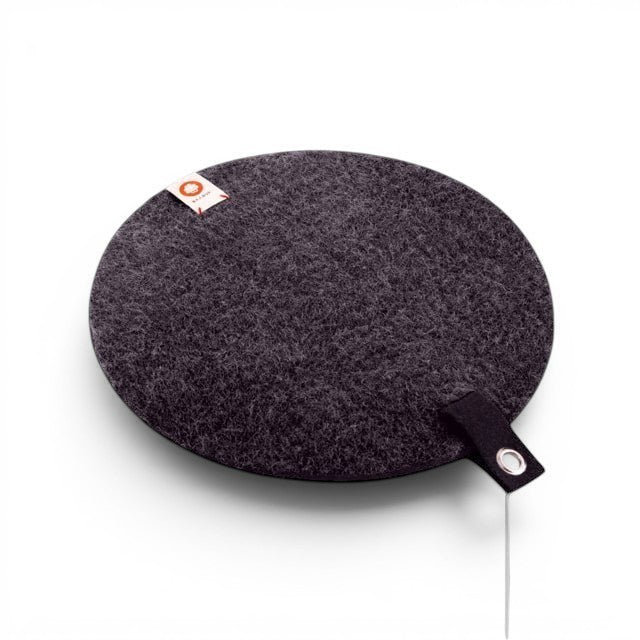 Baabuk dark grey round felted wool trivet with a leather hanging strap and small brand tag on a light background.