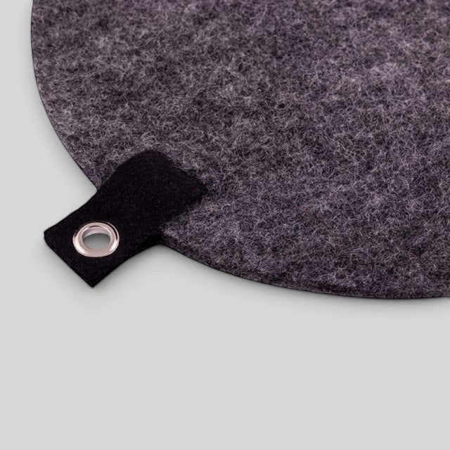Baabuk dark grey felted wool trivet hot plate with a black leather hanging strap and metal grommet.