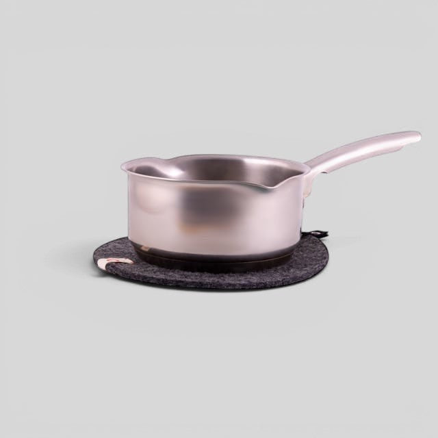 Baabuk dark grey felted wool trivet hot plate with a stainless steel saucepan on top