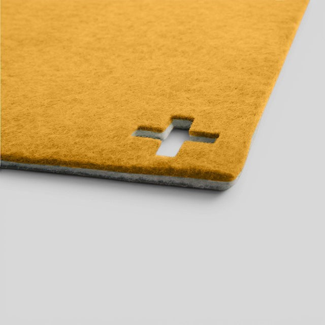 Baabuk honey yellow felted wool table mat with a Swiss cross cutout detail, handmade from natural New Zealand wool.
