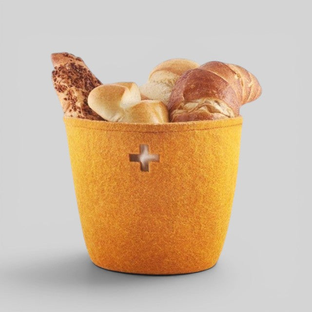 Baabuk small honey-coloured felted wool basket filled with bread, featuring a Swiss cross cutout design.