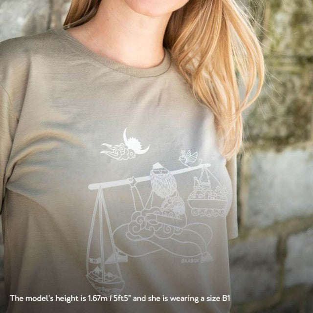 Baabuk limited edition khaki merino wool t-shirt with white Nepalese artist illustration, worn by a model.