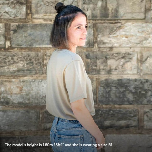 Woman wearing a khaki Baabuk 10 Year Anniversary merino wool T-shirt with a Swiss-inspired graphic, side view.