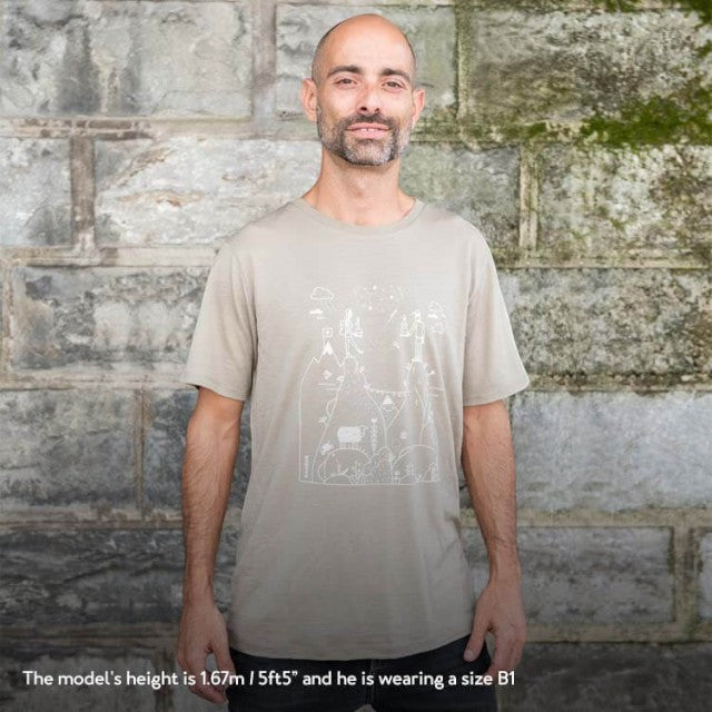 Baabuk khaki merino wool t-shirt with Swiss-themed graphic illustration, worn by a man against a stone wall.