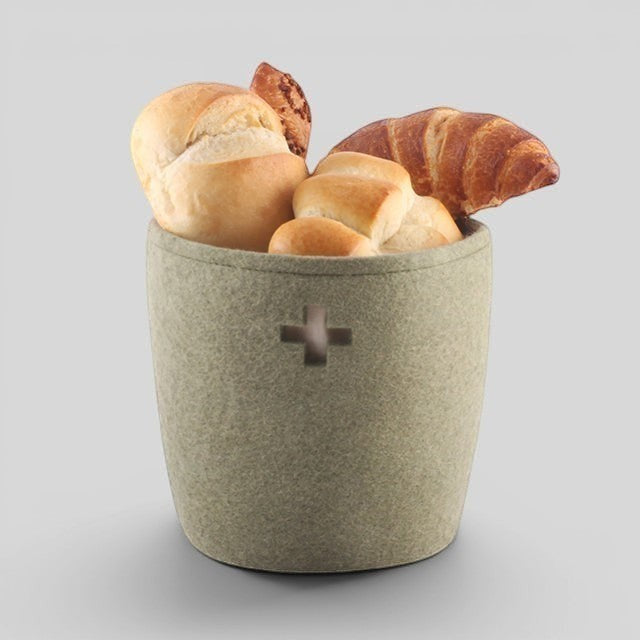 Baabuk small khaki felted wool basket with Swiss cross detail, filled with fresh bread rolls and a croissant.
