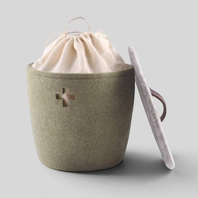 Baabuk small khaki felted wool basket with Swiss cross cutout, fabric liner, and lid with leather strap.