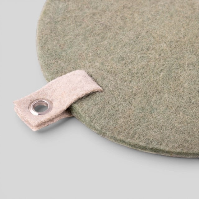 Baabuk khaki felted wool trivet hot plate with a small hanging strap and metal eyelet for kitchen surface protection.