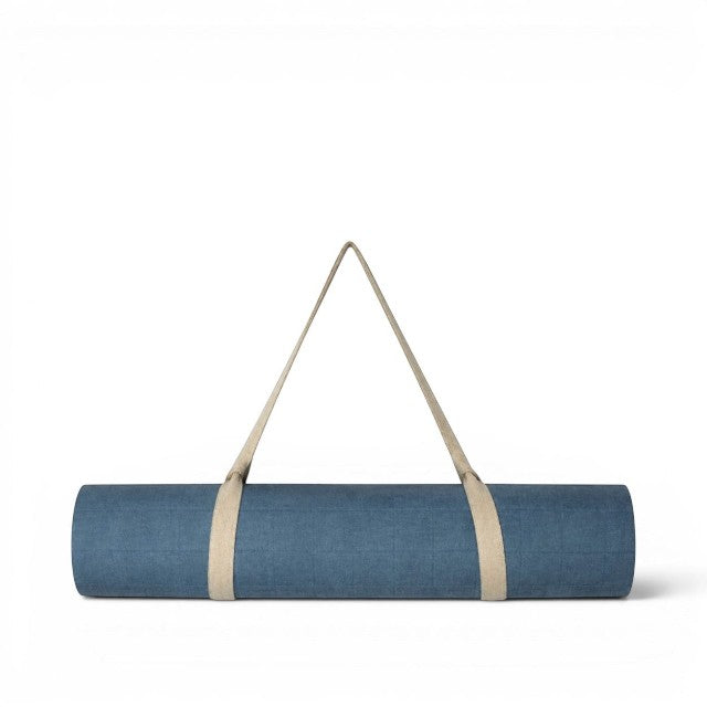 Baabuk light blue felted wool yoga mat rolled up with a beige cotton carrying strap against a white background.