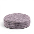 Baabuk set of four round light grey felt coasters made from 100% natural wool for furniture protection.