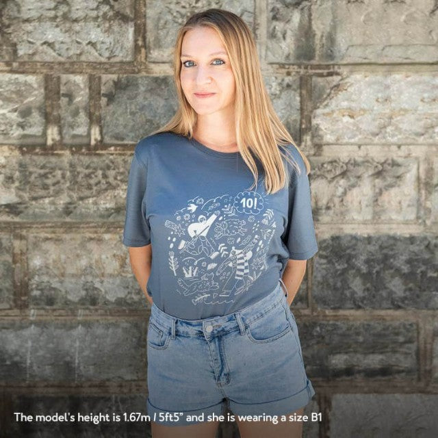 Model wearing a dark grey Baabuk 100% merino wool T-shirt with a white 10th anniversary illustration by Ana Seixas.