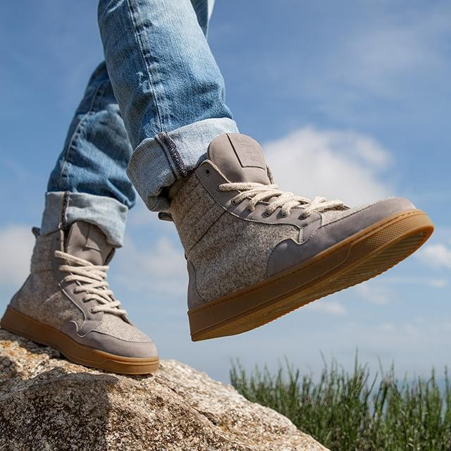 Baabuk Peaks Wooler high-top sneakers in warm grey Pyrenean wool with natural rubber soles worn on a rocky trail.