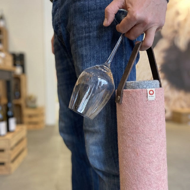 Baabuk pink wool wine cooler with leather strap, holding a wine glass. Perfect for picnics or camping.