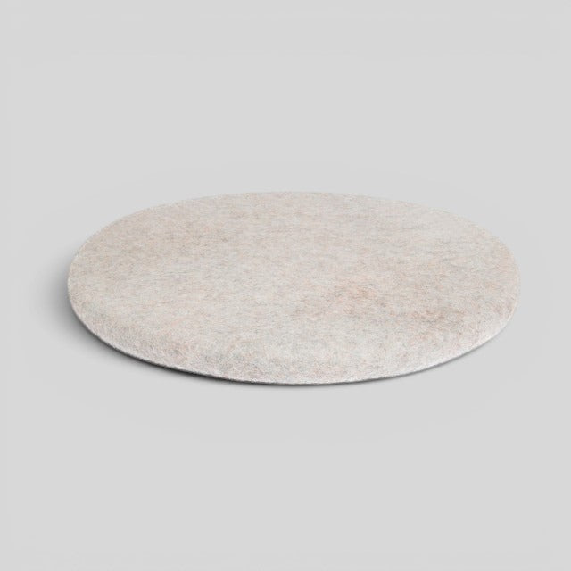 Baabuk handmade round sitting mat made from natural New Zealand wool in a light beige speckled tone.