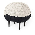 Baabuk Sheep Stool featuring layered white and black wool felt in a rounded sheep shape on dark wooden legs.