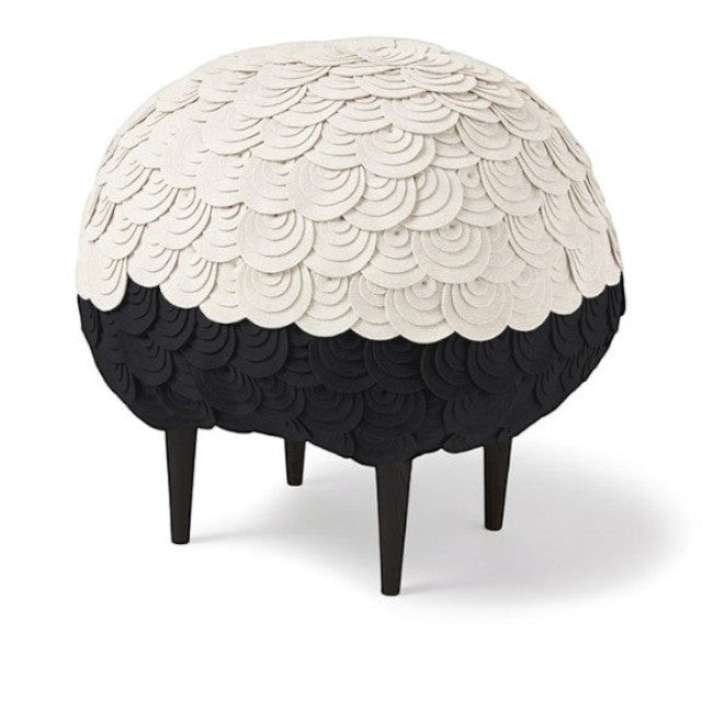 Baabuk Sheep Stool featuring layered white and black wool felt in a rounded sheep shape on dark wooden legs.