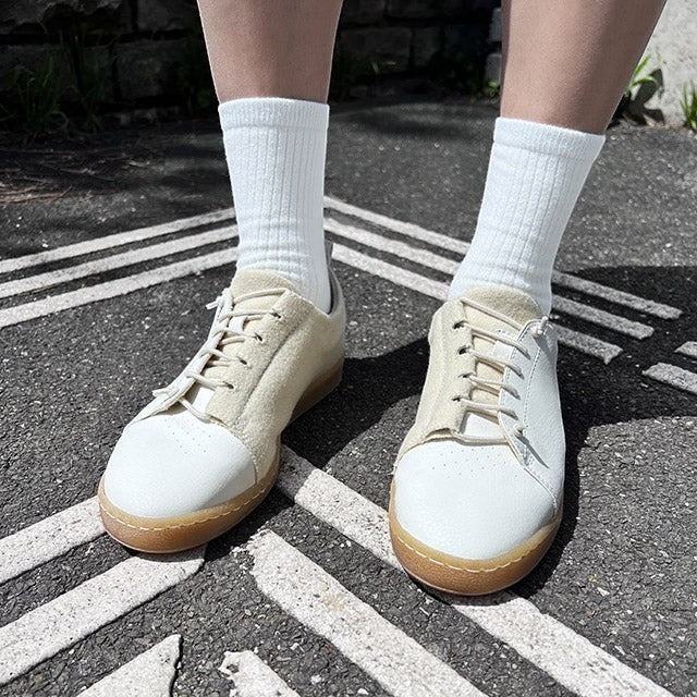 Baabuk Shunya Wooler white sneakers made from Burel wool and plant-based materials worn with white socks on asphalt