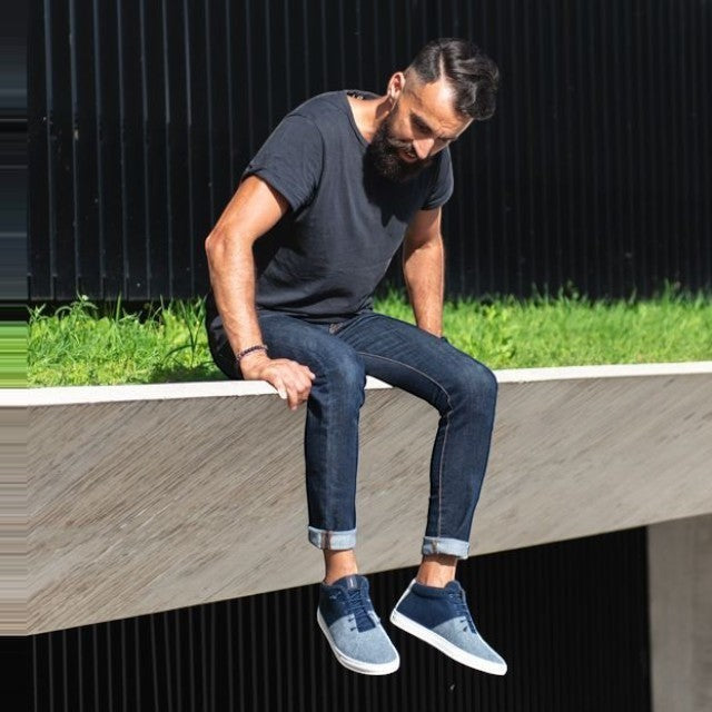 Baabuk Sky Wooler sneakers in blue wool worn by a man in jeans, featuring a white rubber sole and elastic laces.