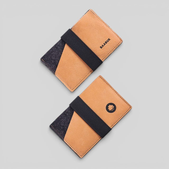 Baabuk slim wallet made of tan leather and grey wool with a black elastic strap to secure cash and cards.