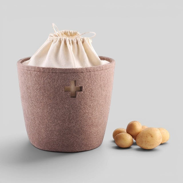 Baabuk small brown felted wool basket with a cream drawstring liner and Swiss cross cutout detail.