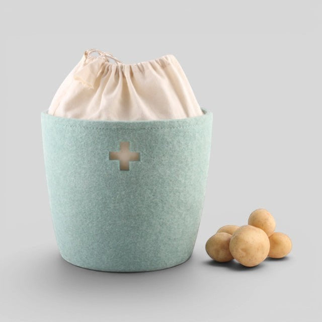 Baabuk small light blue felted wool storage basket with a Swiss cross cutout and cream fabric drawstring liner.