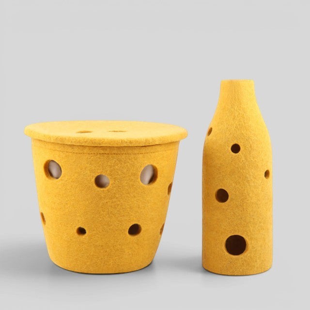 Baabuk small yellow felted wool basket with Swiss cheese-inspired holes for kitchen storage or home decor.