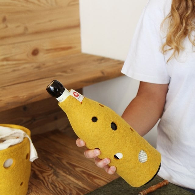 Baabuk yellow wool bottle cover with Swiss cheese hole design, handmade from natural New Zealand wool.