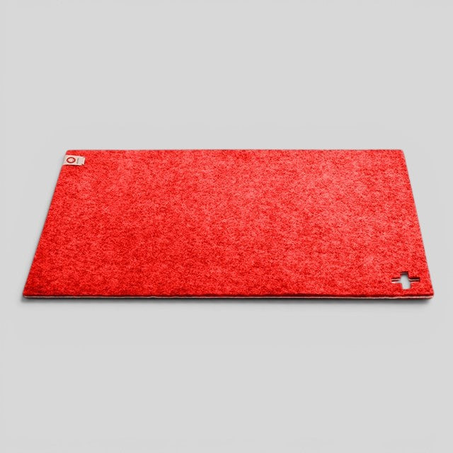 Baabuk Swiss red rectangular table mat made from 100% felted wool with a small cutout Swiss cross detail.