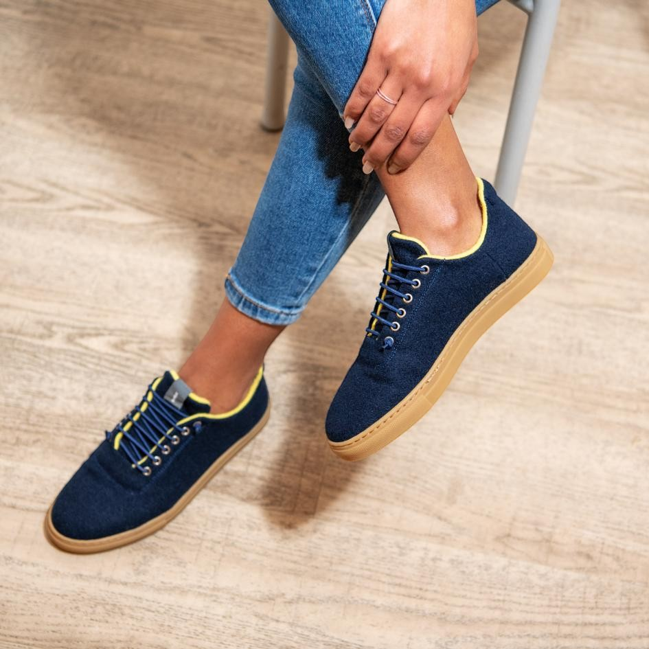 Baabuk Urban Wooler navy blue wool sneakers with yellow trim and elastic laces worn with blue jeans
