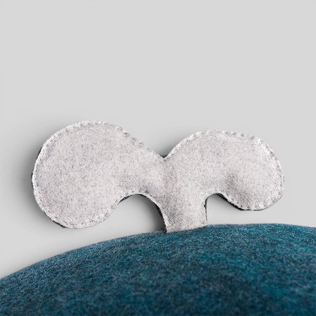 Baabuk Whalebuk wool storage whale featuring a hand-stitched light grey felt tail on a dark blue felt body.