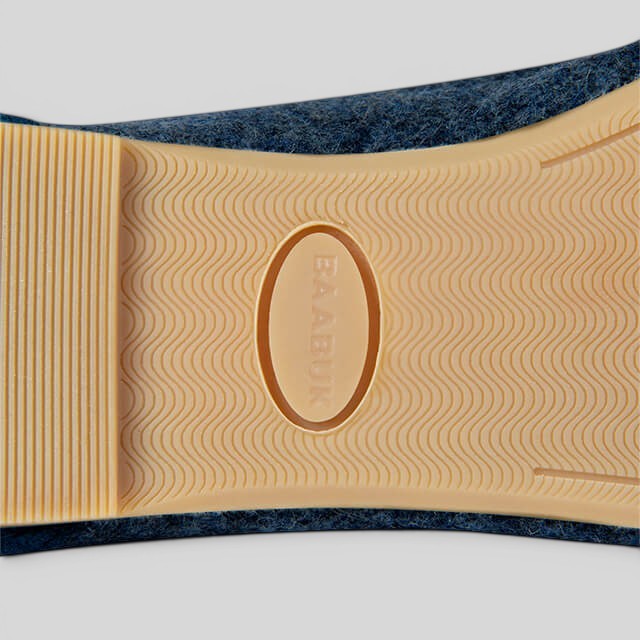 Close-up of the durable rubber sole on a blue Baabuk Wool Ballerina shoe with a textured wave pattern.