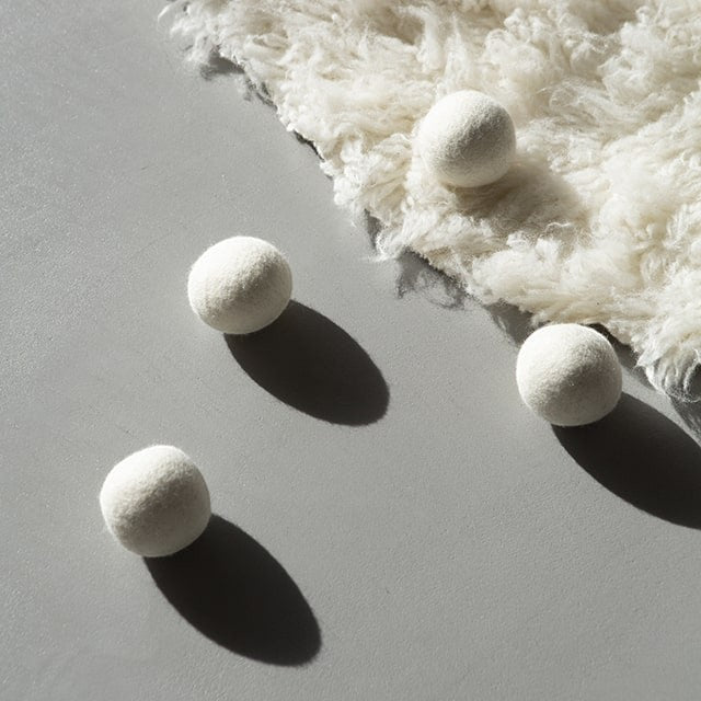 Baabuk white wool dryer balls, a 4-pack of natural, eco-friendly laundry essentials for faster drying and softer clothes.