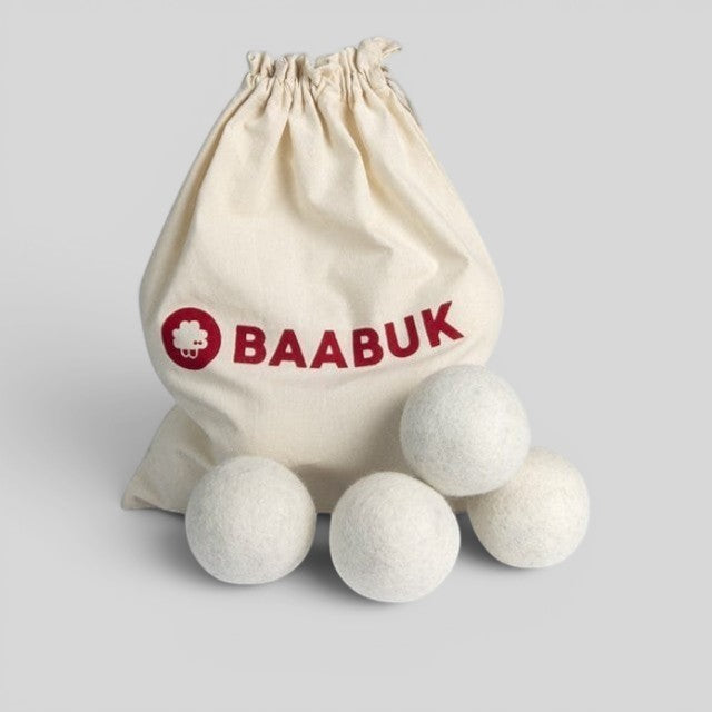 Four white Baabuk wool dryer balls in a branded cotton drawstring carry bag for sustainable laundry care.
