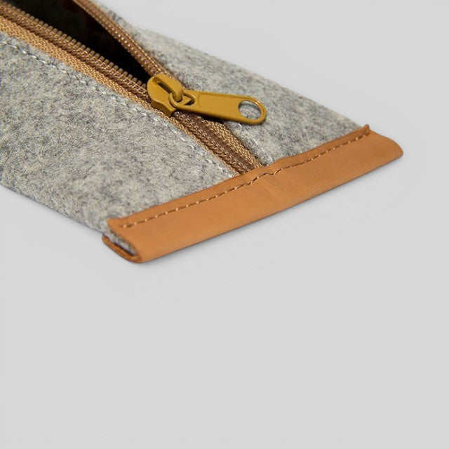 Baabuk grey wool pencil case with tan leather trim and yellow zipper closure. Zippered pouch for pencils and accessories.