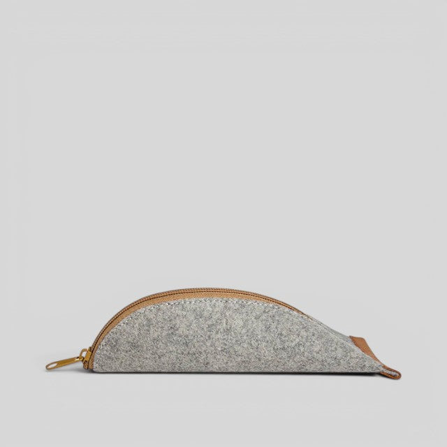 Baabuk grey wool pencil case with leather accents and a gold zipper closure. Sized for pencils and accessories.