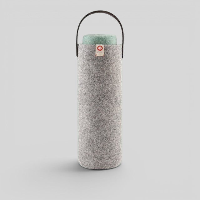 Baabuk light grey wool wine cooler with a leather handle and a green top insert. Designed in Switzerland, handmade in Nepal.